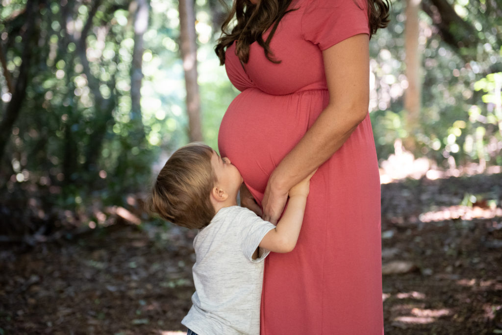 Little boy kissing mamas belly