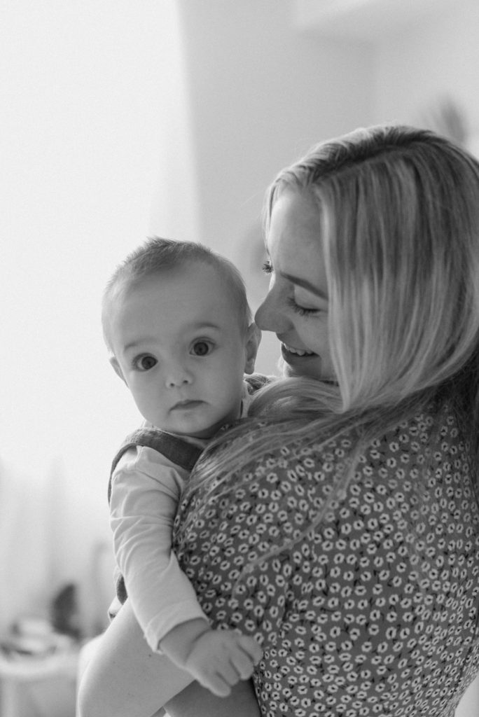 Mom's nose to baby's head.  Baby looking at camera in black and white