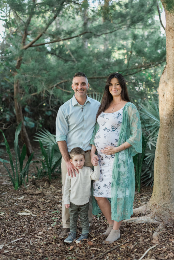 Mom holding belly with dad and son