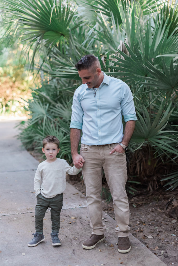 Dad looking down at son, holding hands