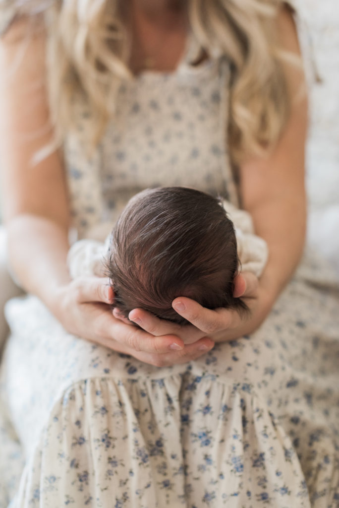 Babies head in mom's hand