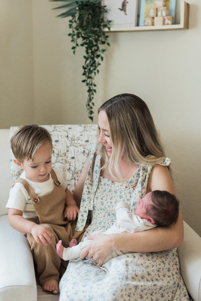 Mom looking at older son, holding baby