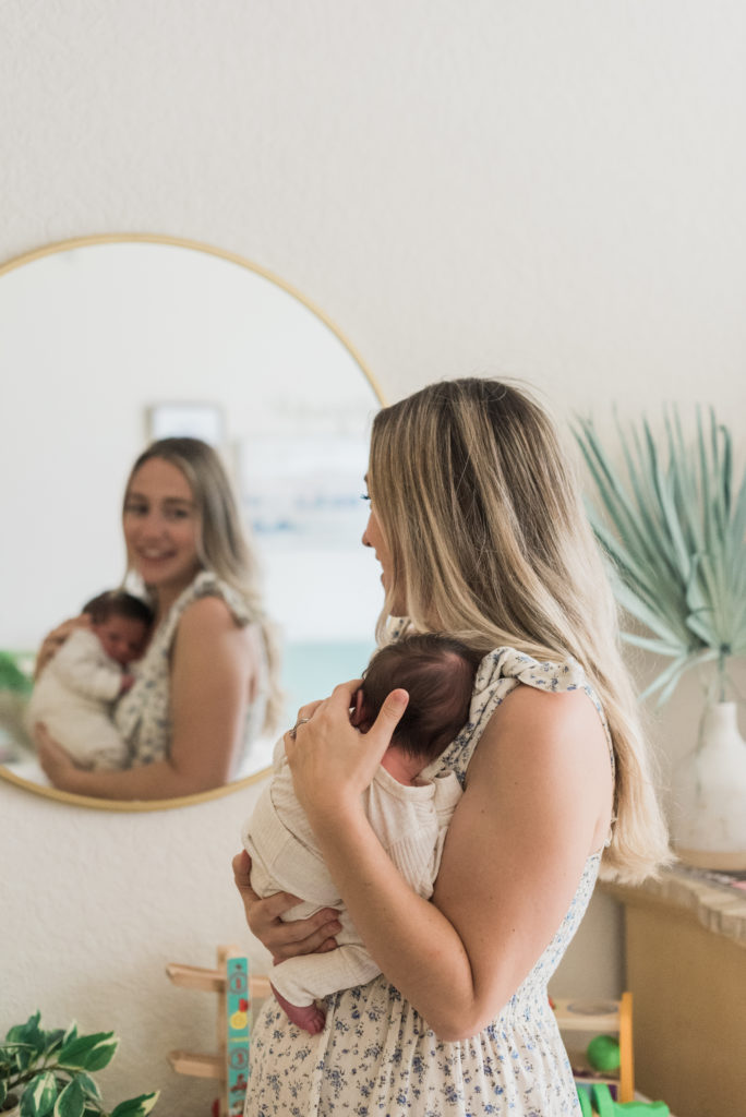 Mom looking in mirror holding baby