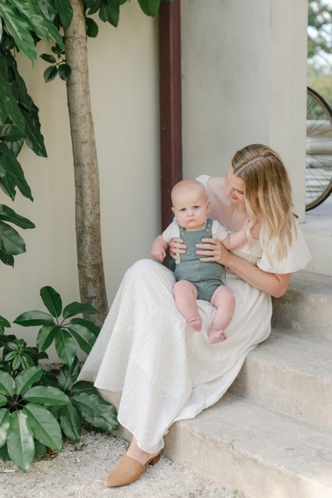 Mom sitting on step looking at baby