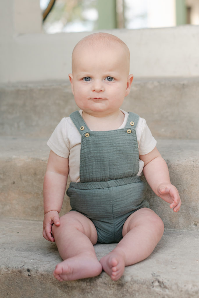 Baby boy sitting on step alone