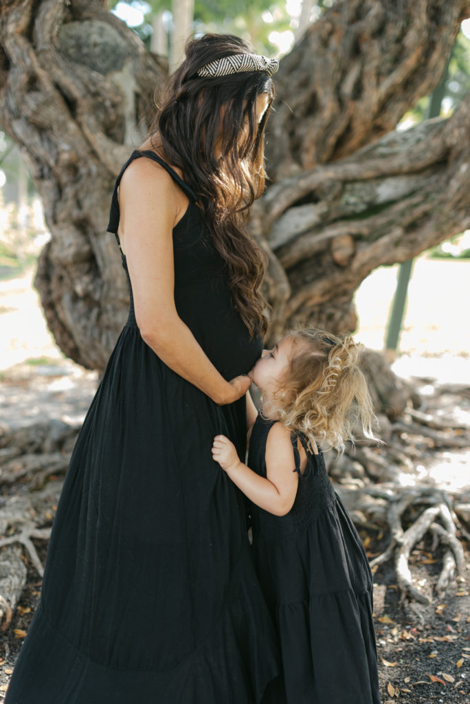 Daughter kissing mom's belly