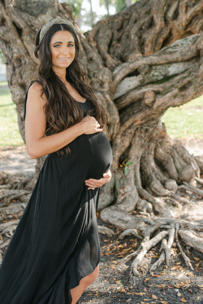 Mom holding belly looking at camera