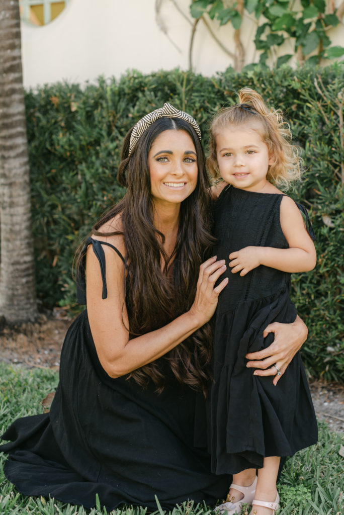 Mom crouched next to daughter 