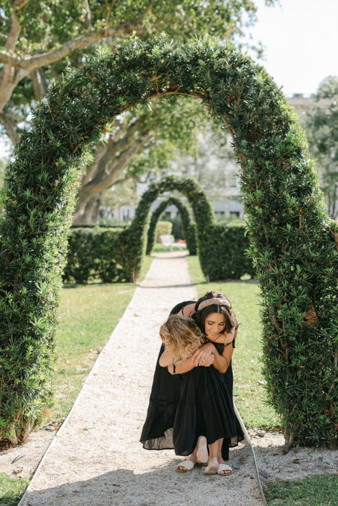 Mother and daughter hugging under arches