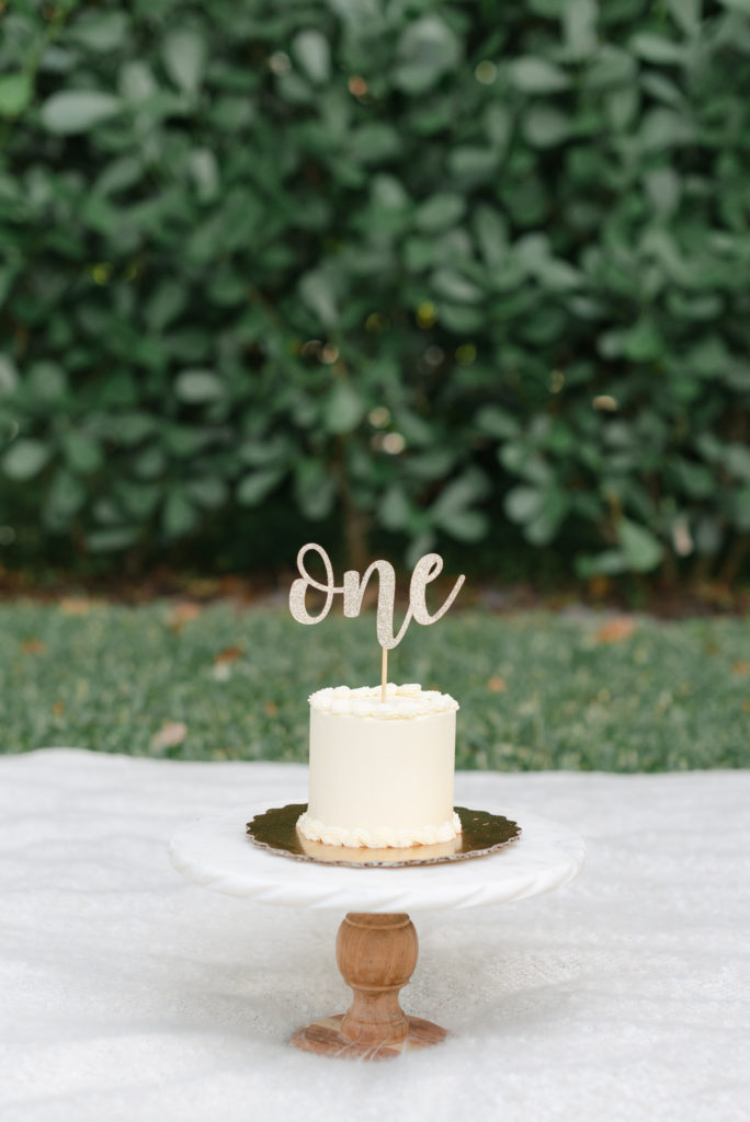 Birthday cake on a cake stand with one cake topper