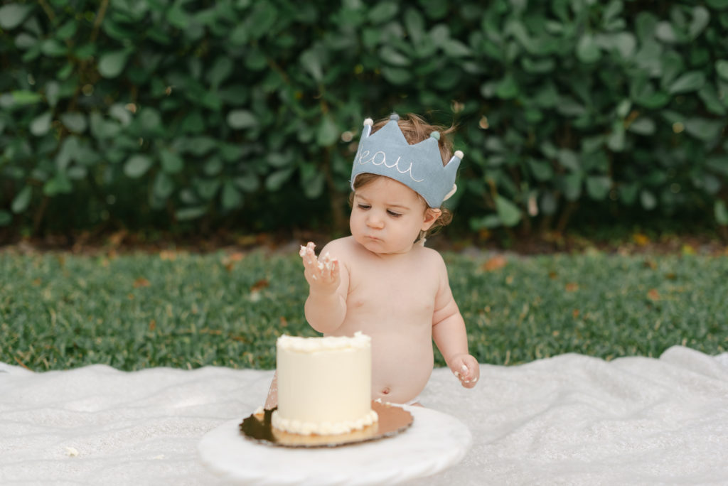 Boy looking at fingers covered in cake