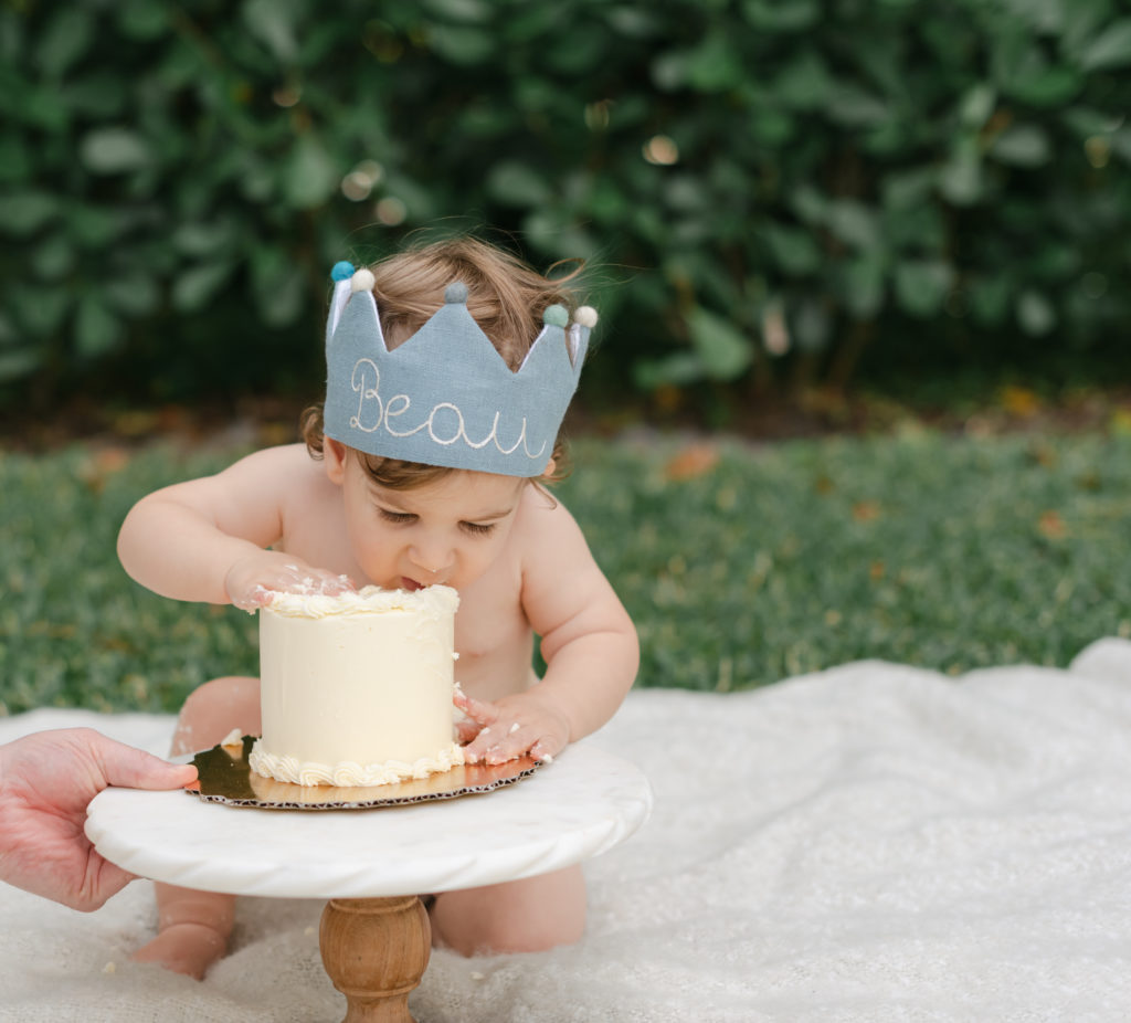 Baby boy taking a bite of cake