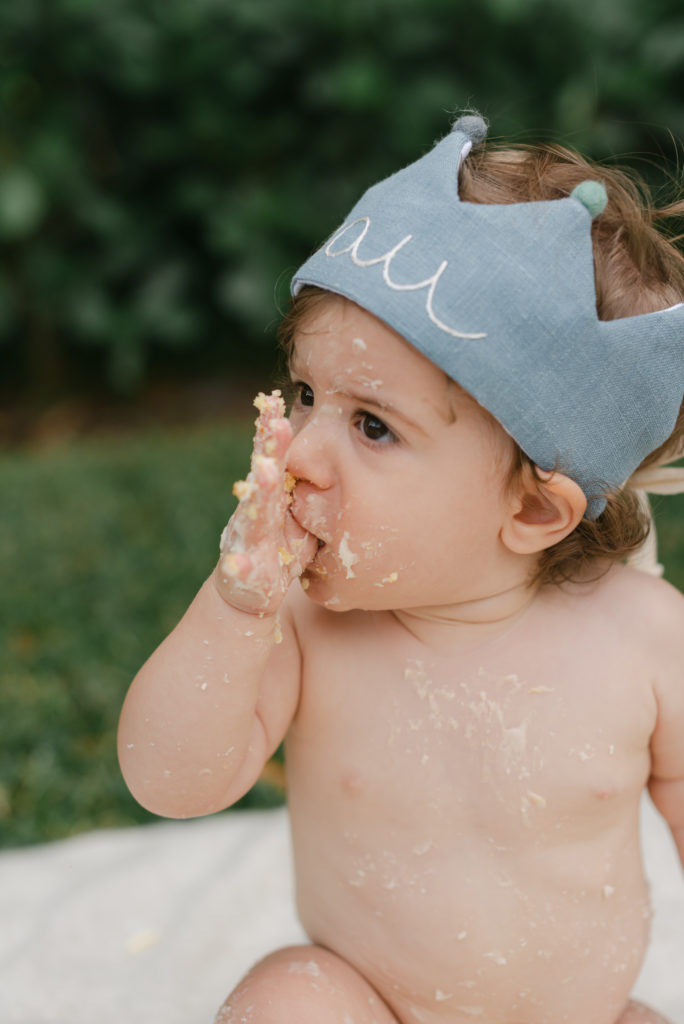 Licking thumb covered in cake