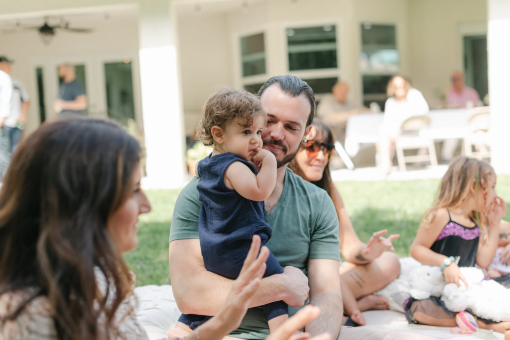 Dad holding birthday boy watching music teacher