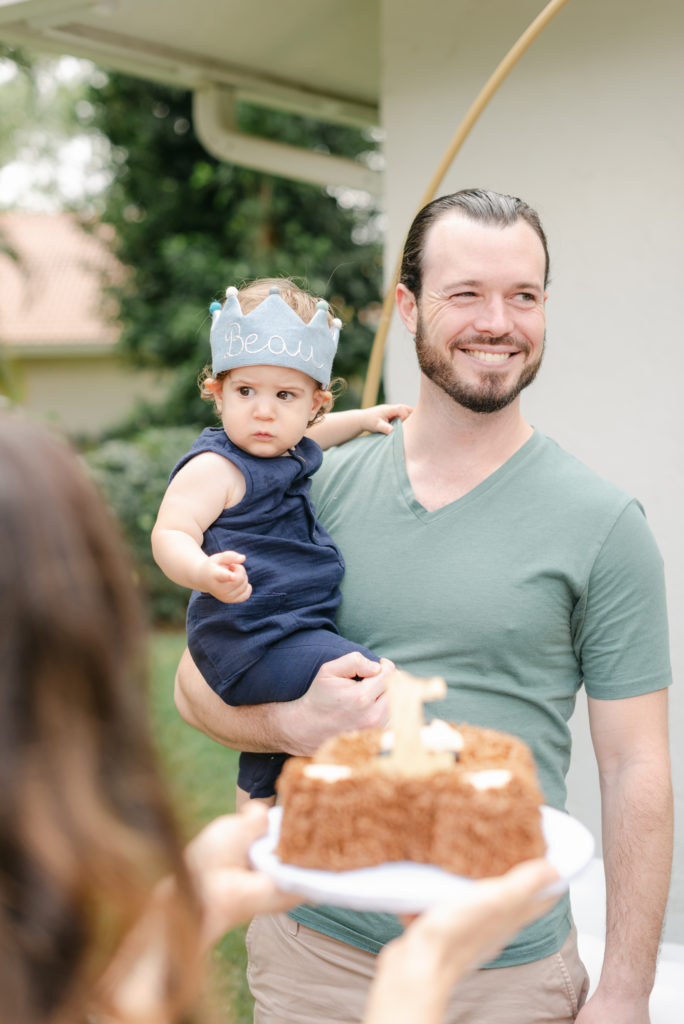 Dad smiling holding birthday boy