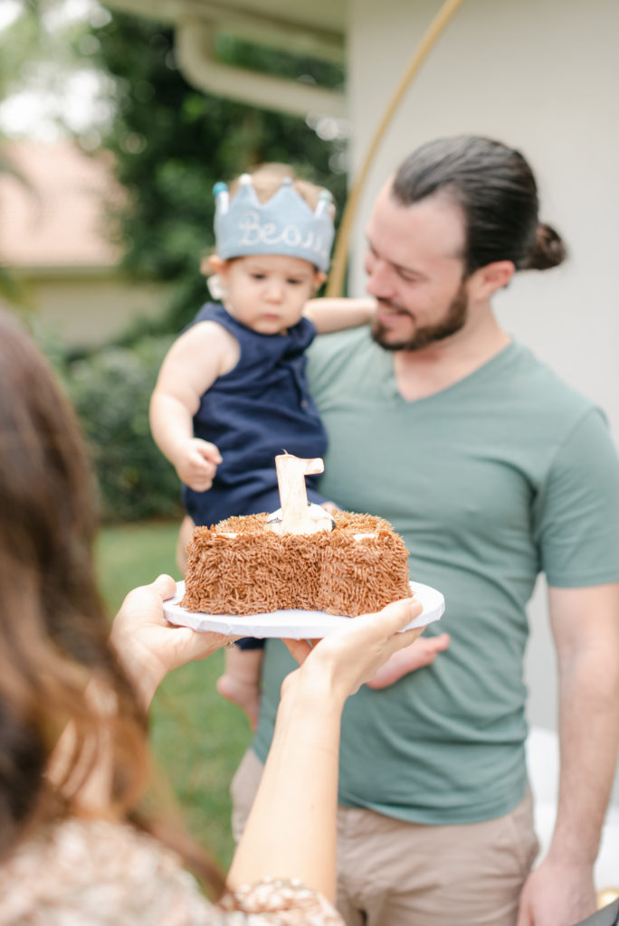 Mom holding cake bringing to birthday boy