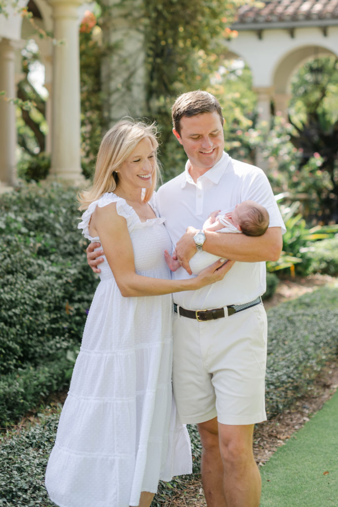 Mom and dad holding baby girl looking at her