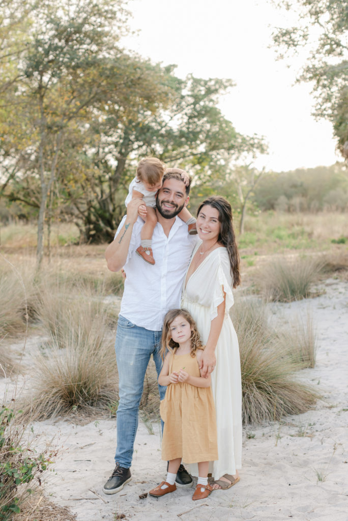 Daughter on dad's shoulders, other daughter in front of mom