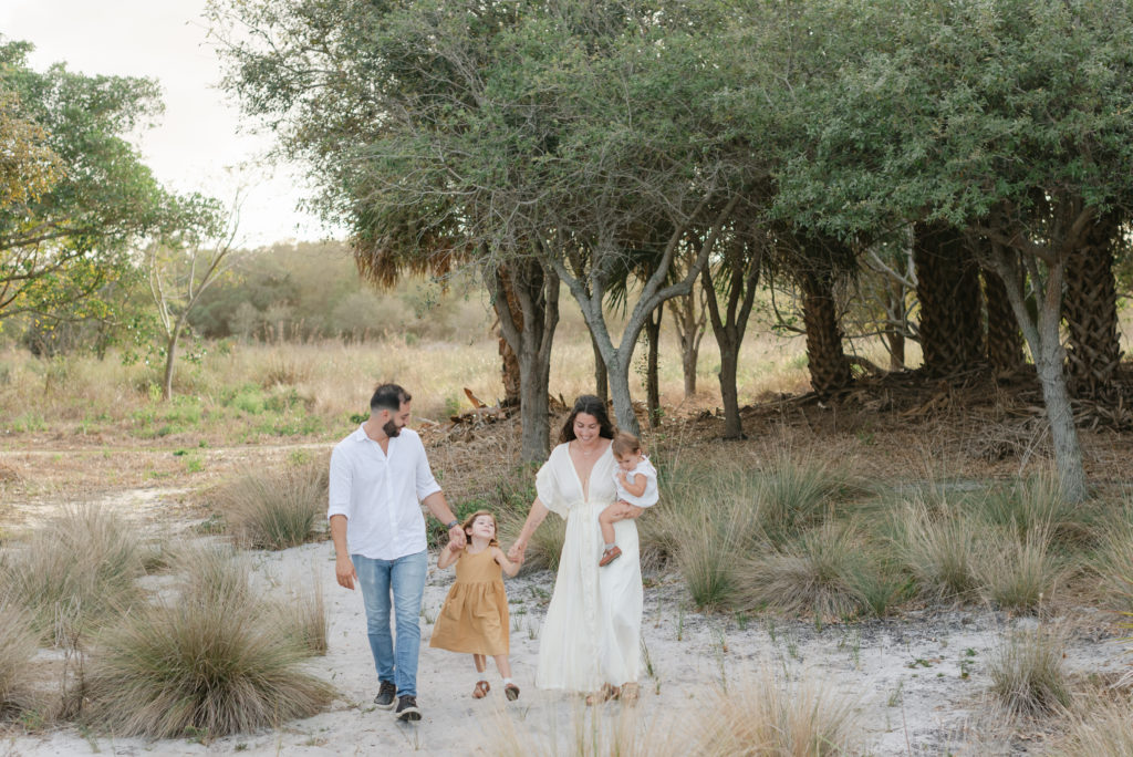 Family walking towards me, holding hands