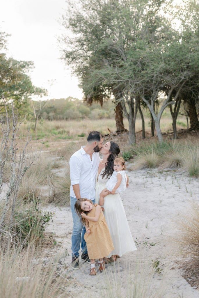 Mom and dad kissing, girls looking at camera