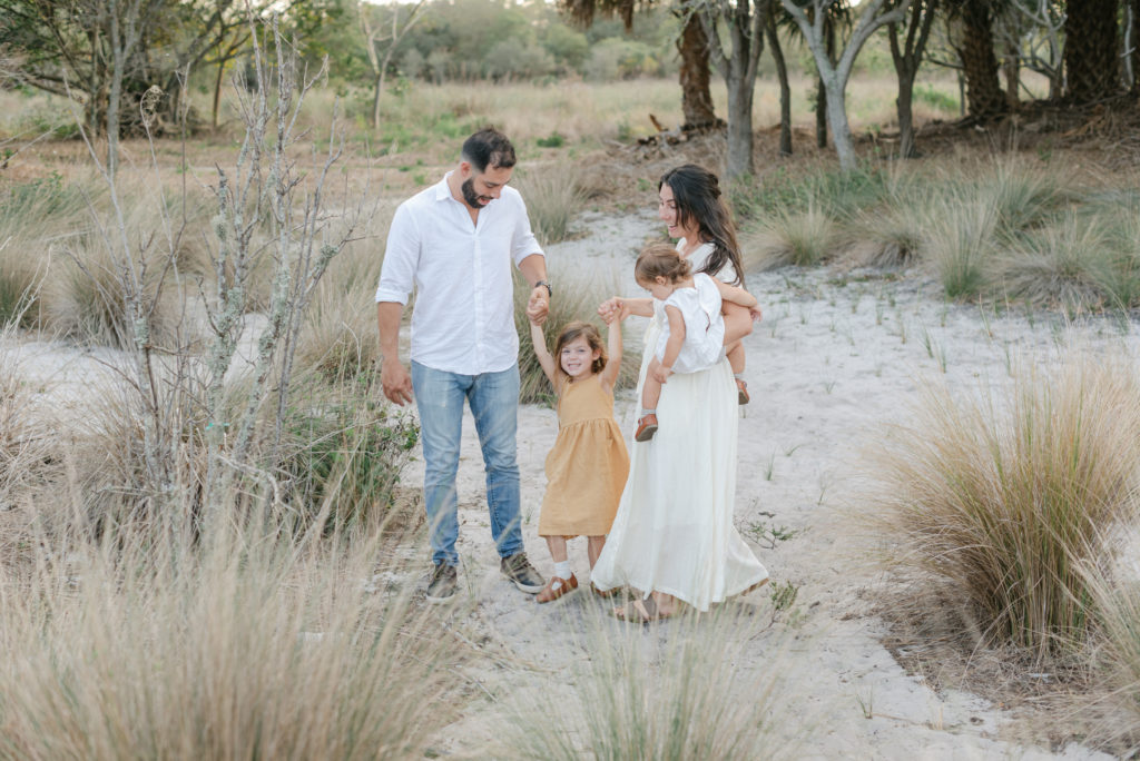 Mom holding baby, about to lift daughter with dad