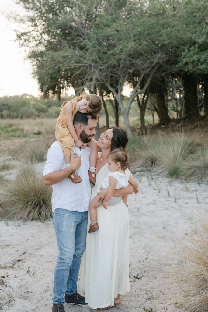 Mom looking up at daughter on dad's shoulders