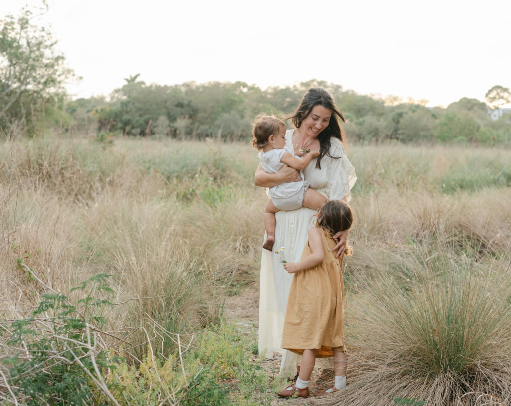 Mom holding daughter, embracing other daughter