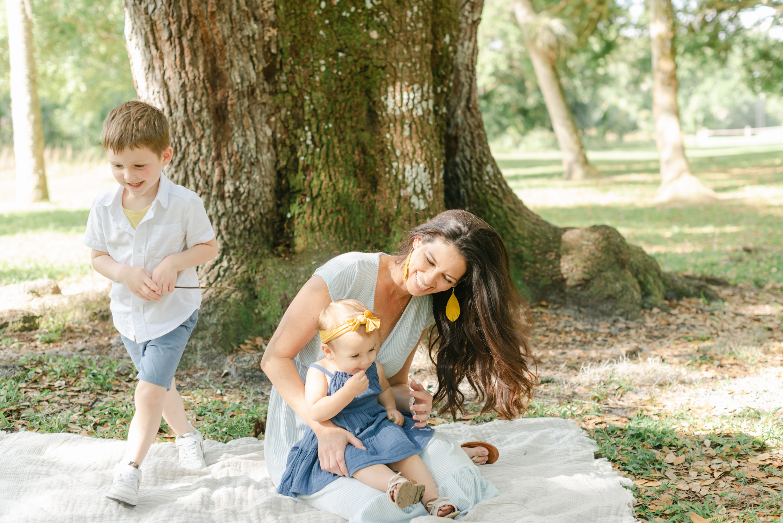 Mom laughing at son, with daughter in her lap