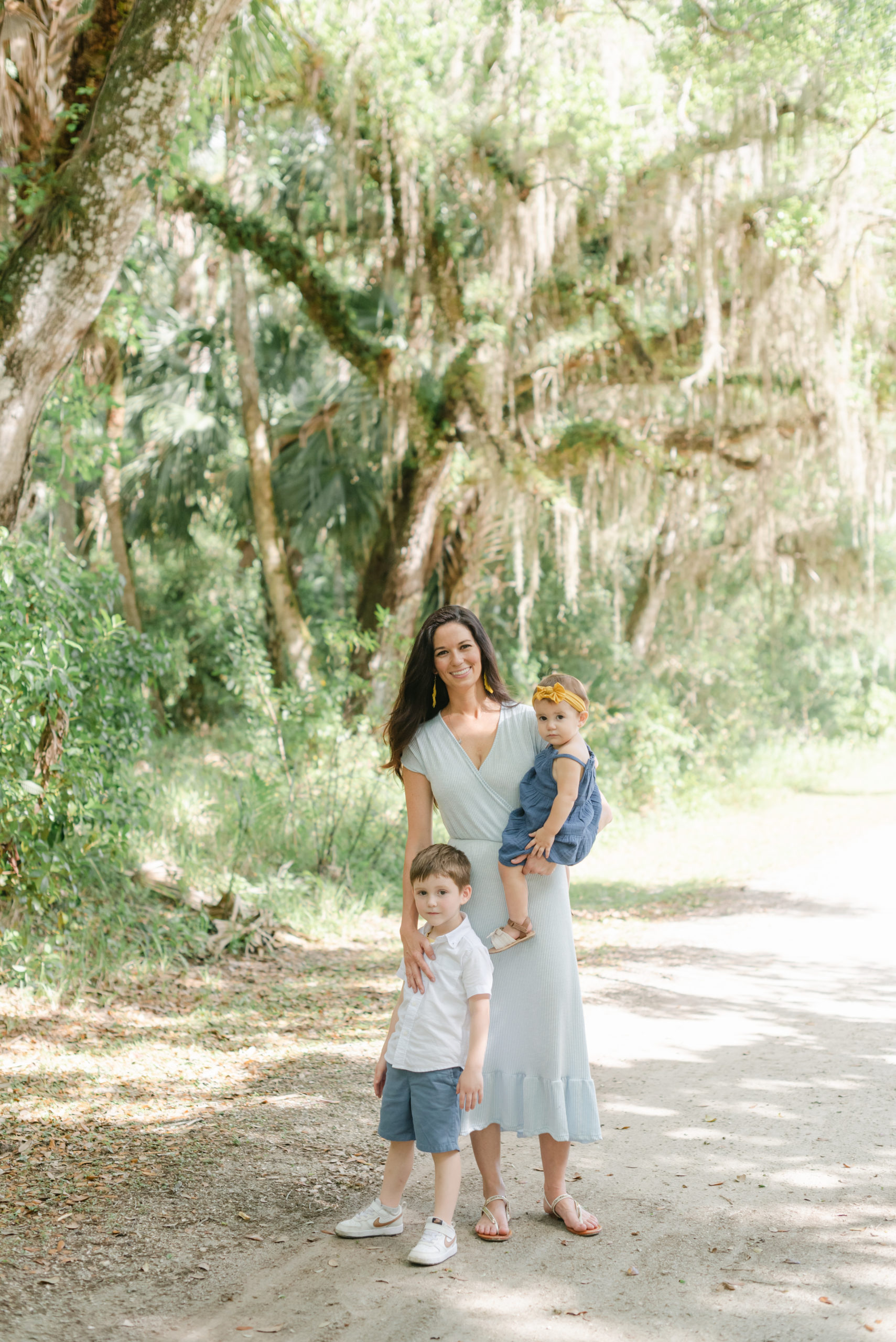 Mom holding daughter, arm on son