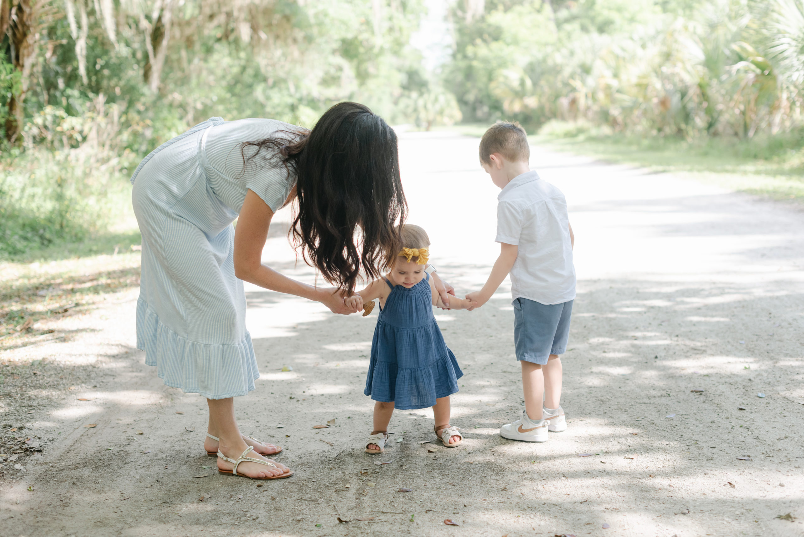 Mom and son holding daughter's hand