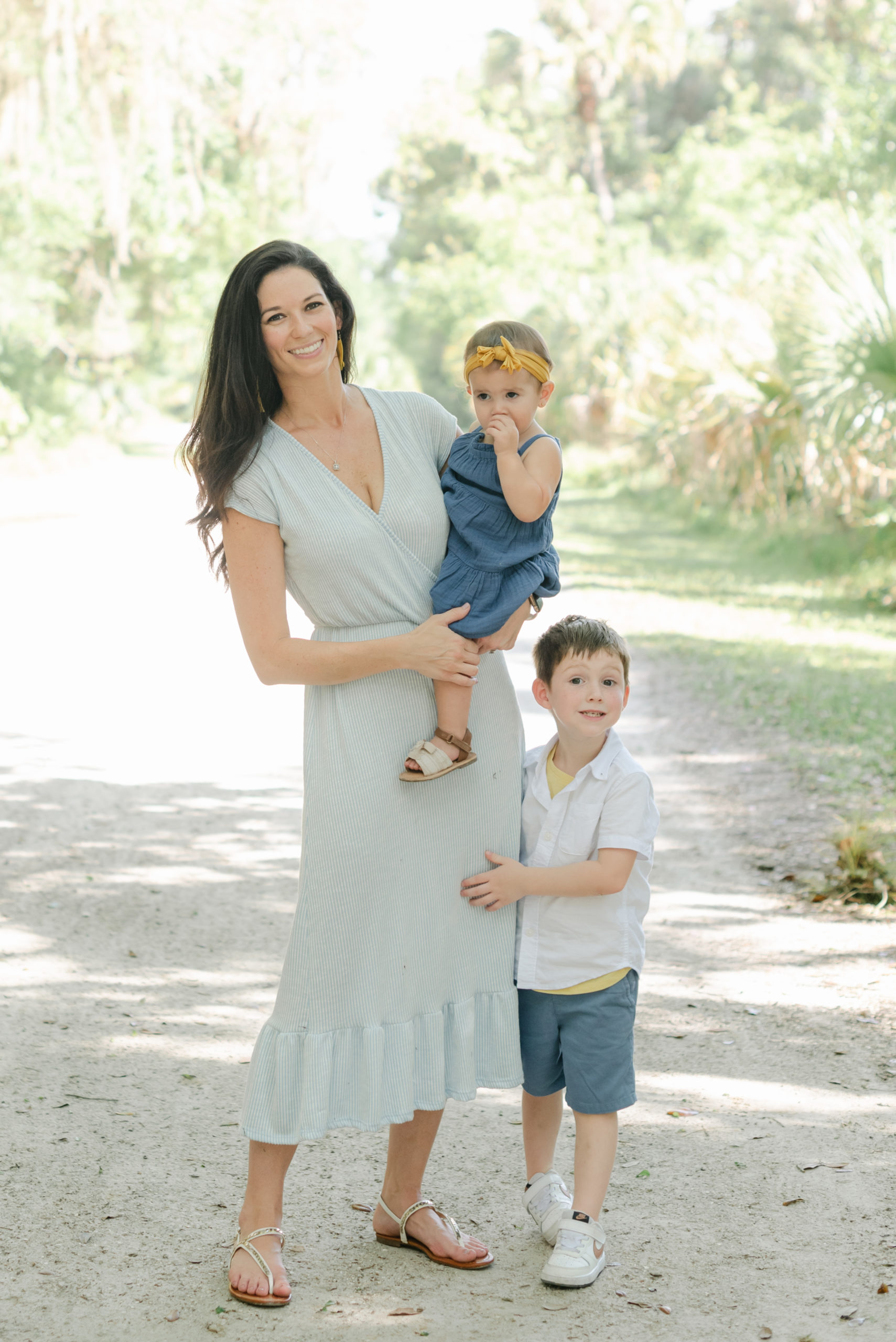 Mom holding daughter, son holding mom's leg