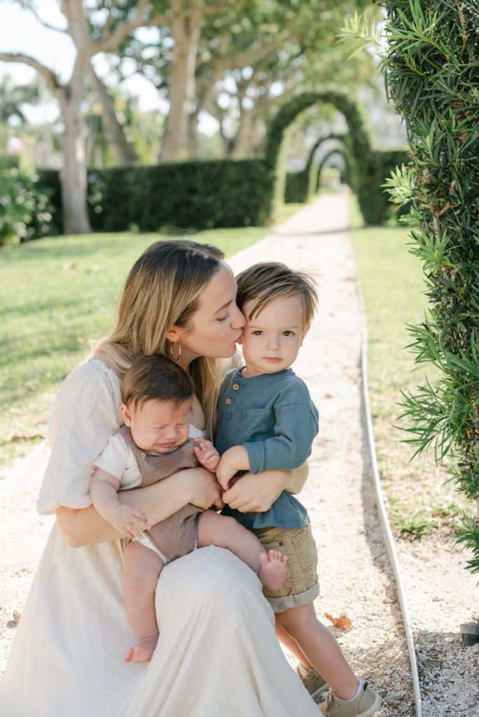 Mom crouched down kissing son