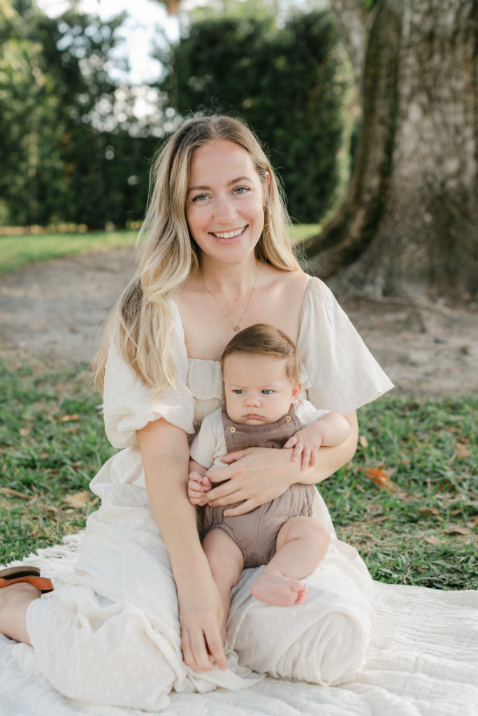 Mom sitting smiling holding baby