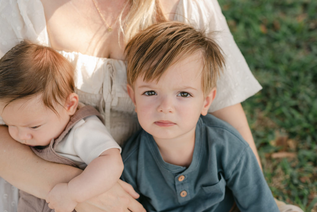 Son's sitting on her lap, toddler boy looking up