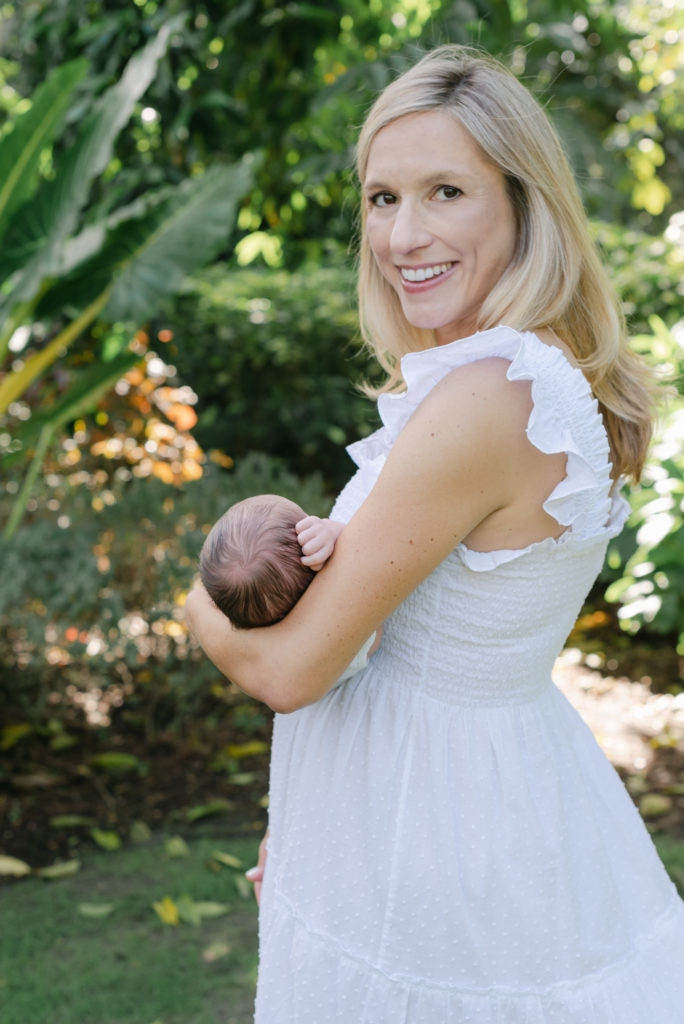 Mom smiling at me, holding baby