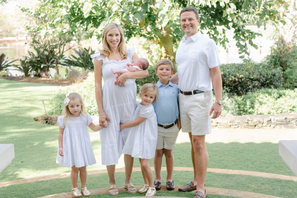 Family standing, girls holding mom's leg