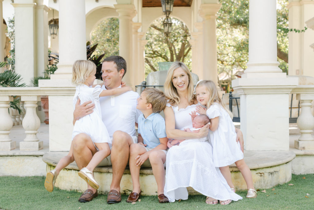 Family sitting on step half looking at me, half looking at each other