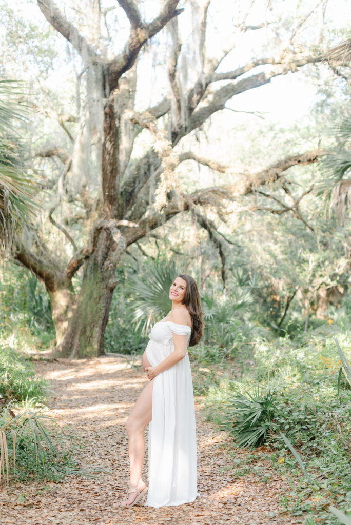 Mom holding belly under tree