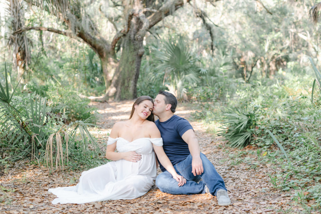 Sitting on ground, dad kissing mom's head