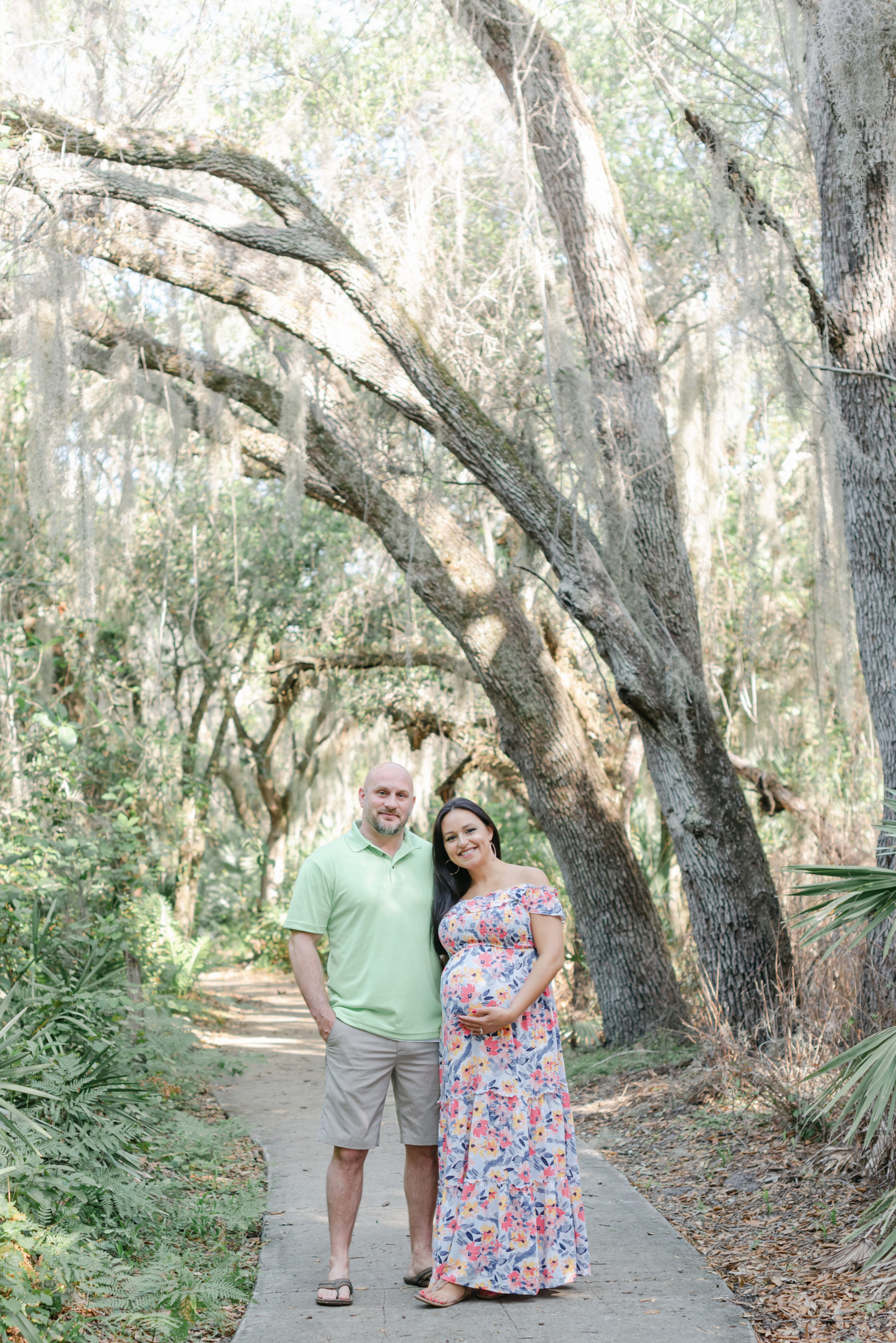 Mom and dad holding belly, smiling