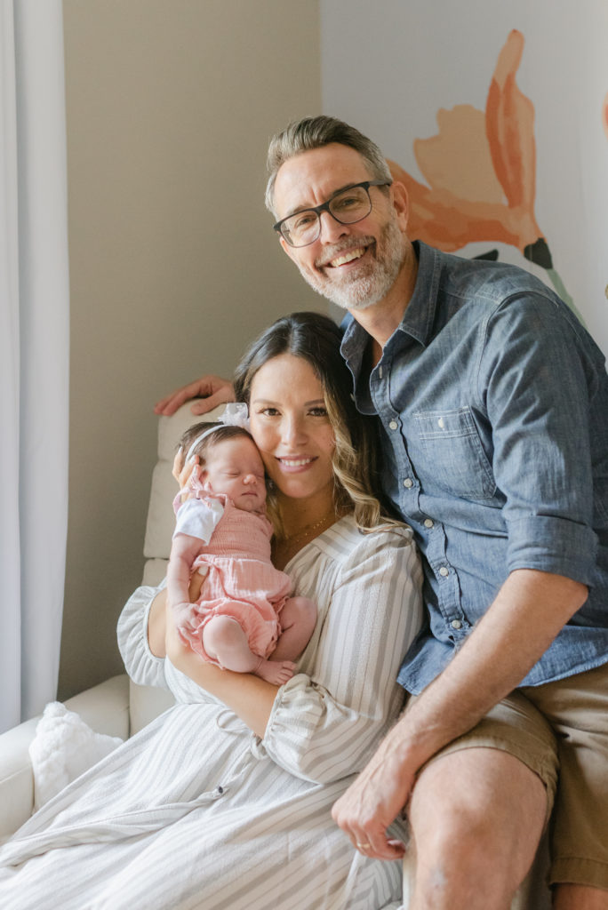 Mom dad and baby sitting in a chair