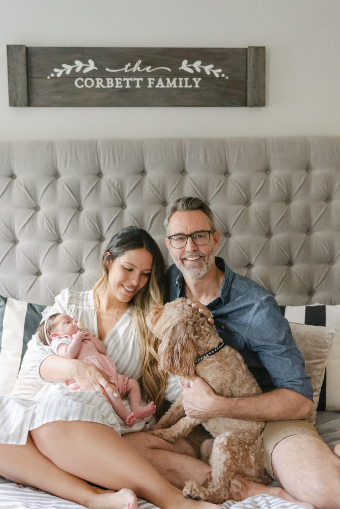 Mom, dad and dog sitting on bed