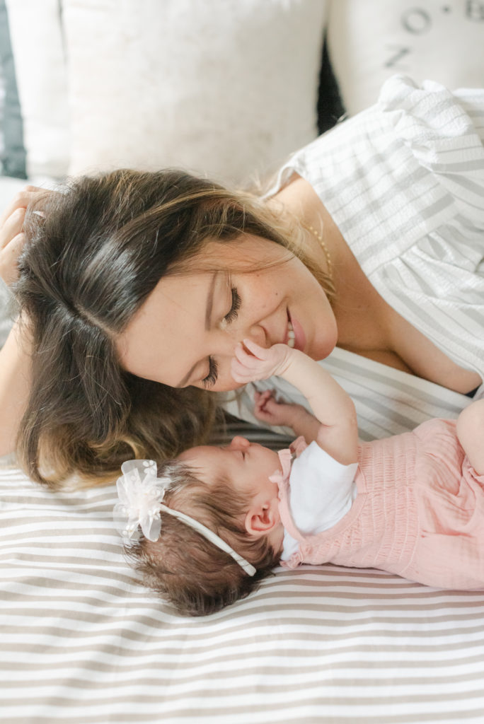 Baby girl grabbing mom's nose