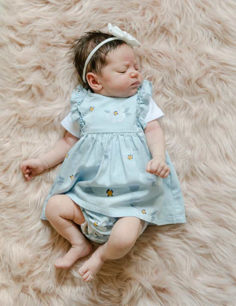 Baby girl looking away laying on carpet