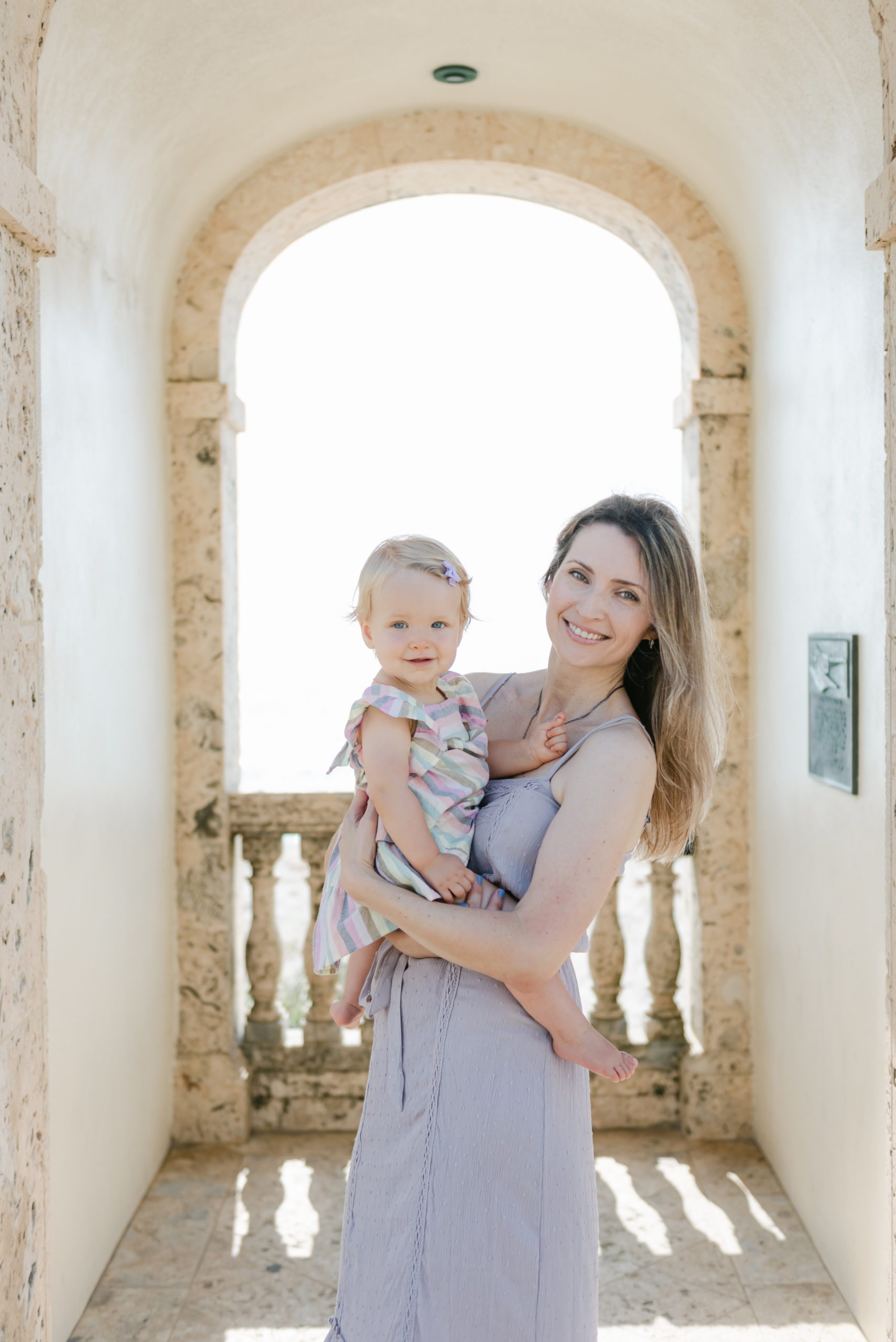 Mom and daughter smiling under bell tower