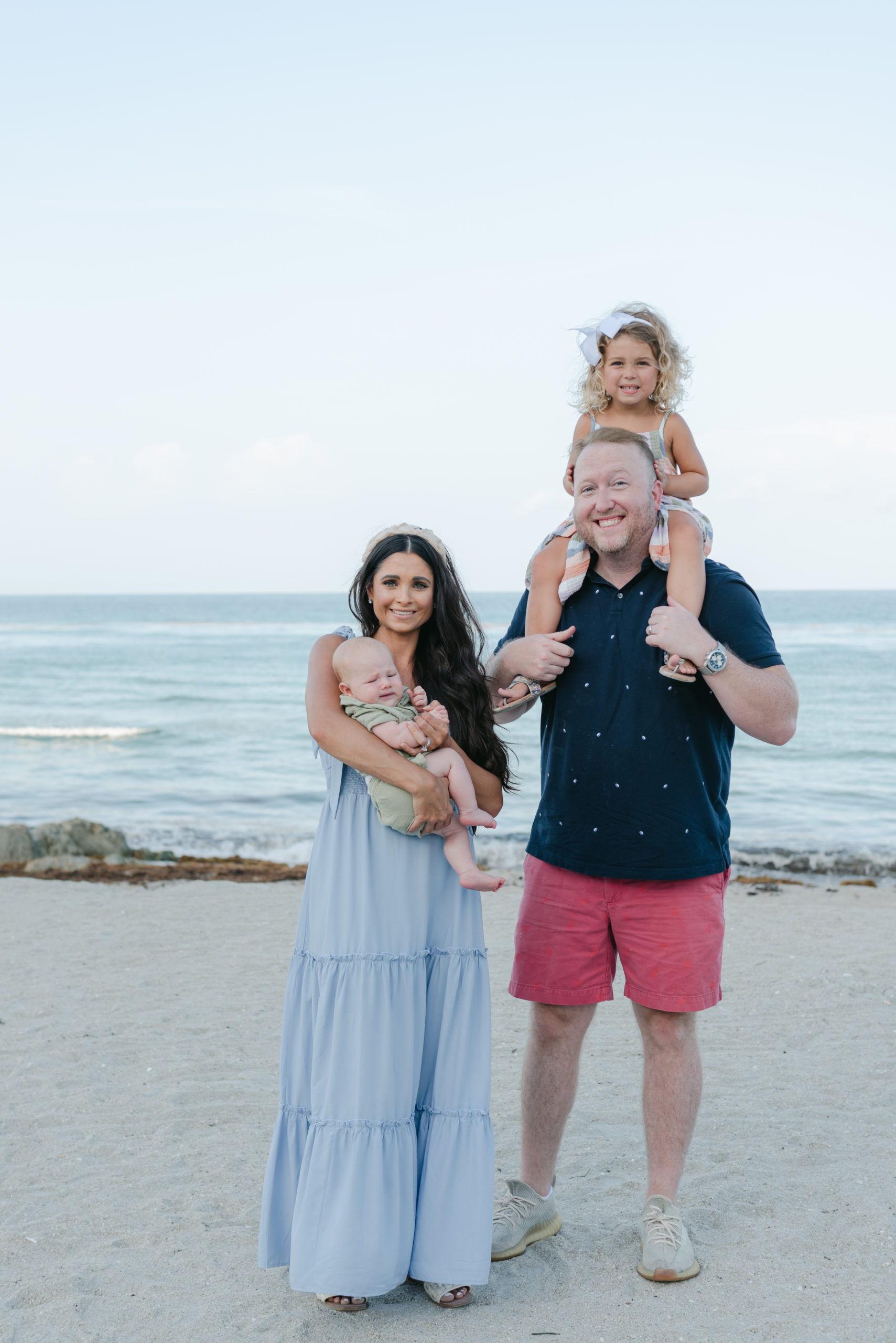 Daughter on dad's shoulders, mom holding baby