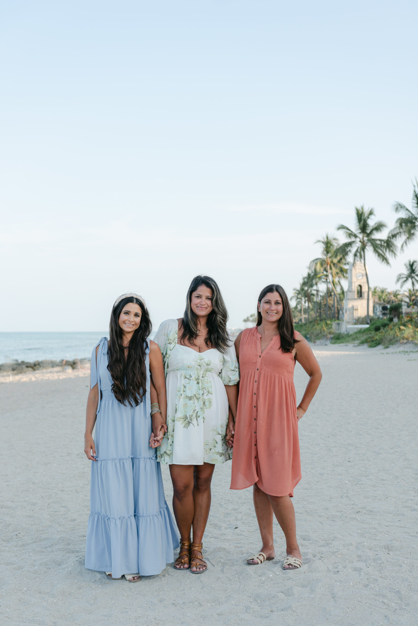 Three sisters holding hands on the beach