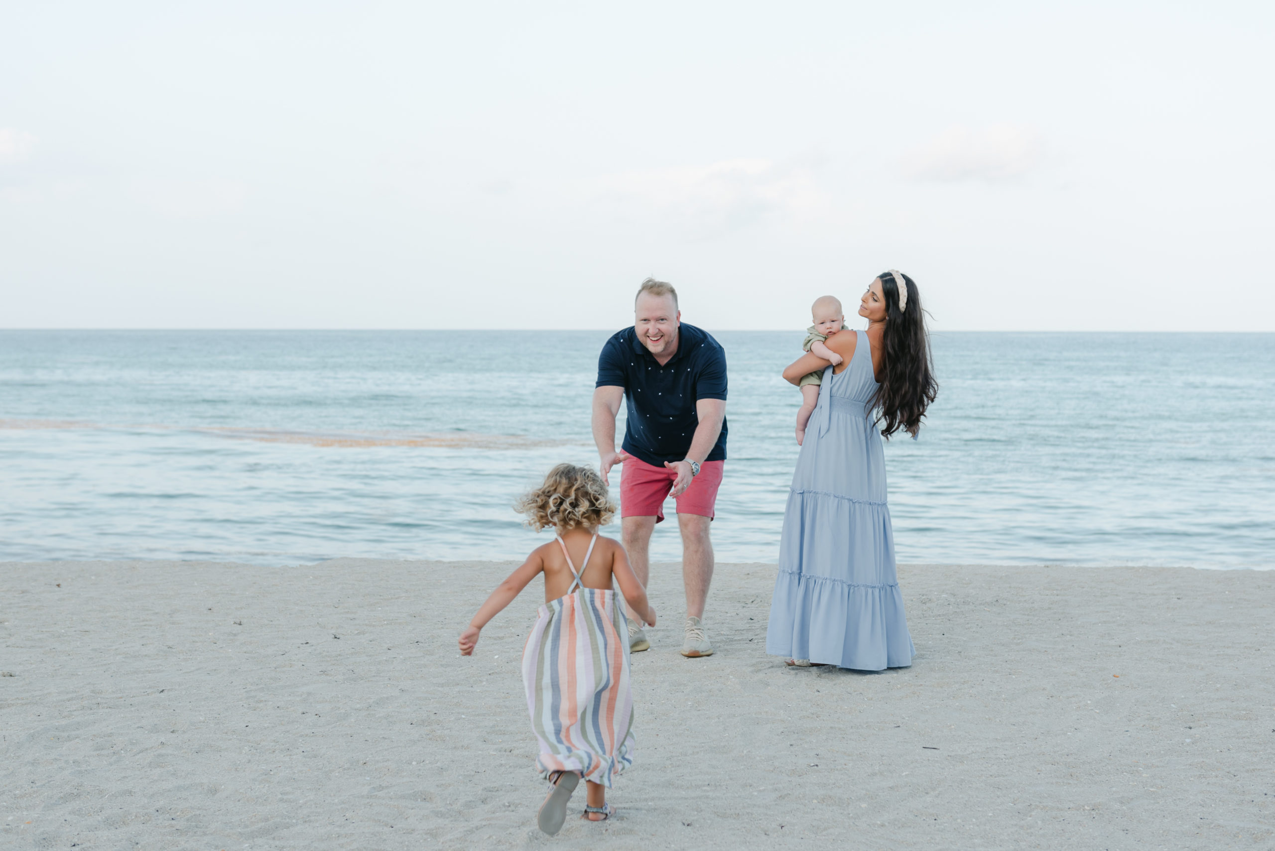 Daughter running to dad, mom holding baby