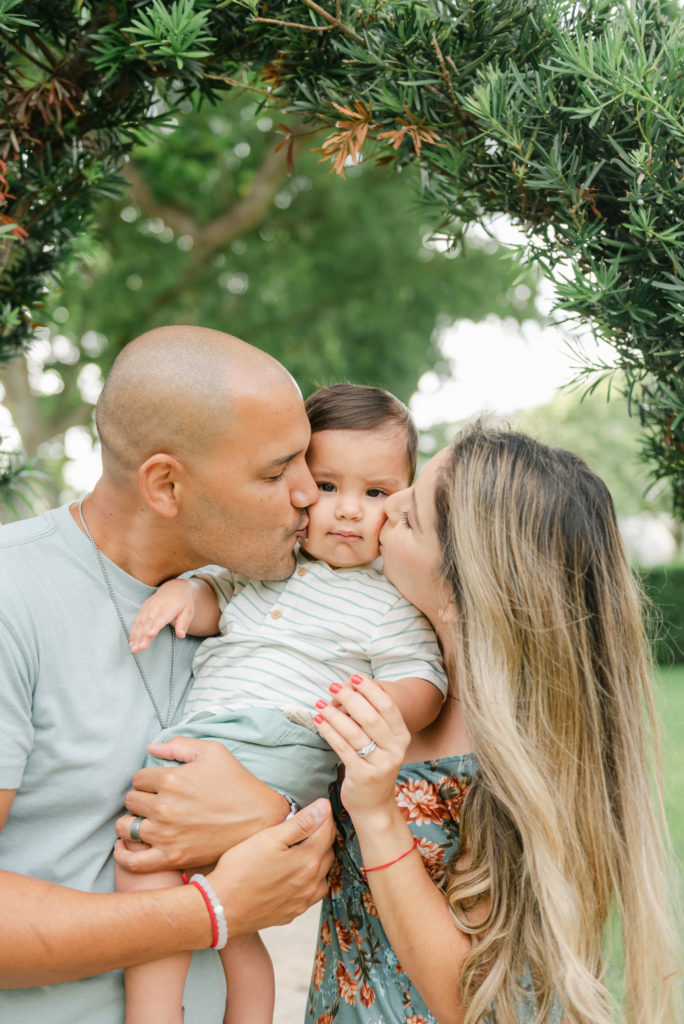 Mom and dad kissing son