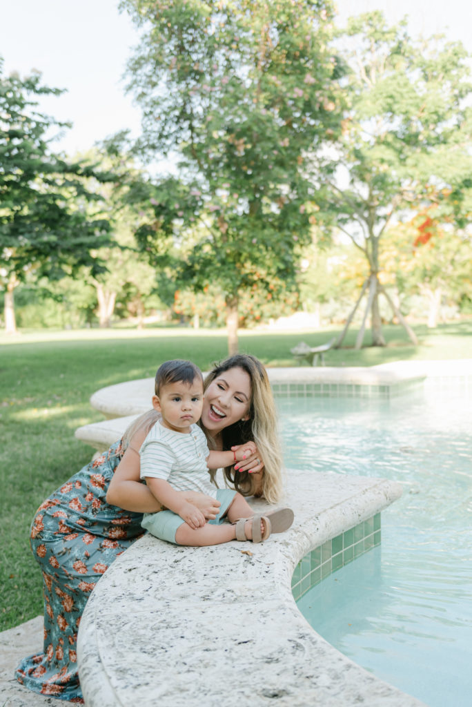 Mom crouching by son near fountain